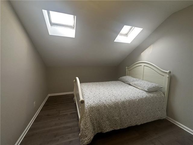 bedroom with vaulted ceiling, dark wood finished floors, and baseboards