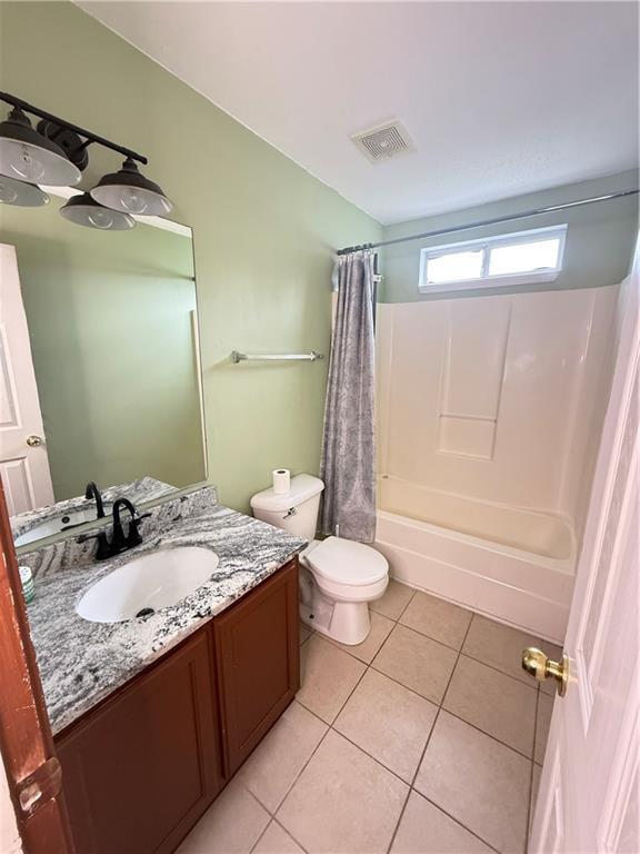 2658 Deann Dr, Ellenwood, GA 30294 - bathroom featuring vanity, tile patterned flooring, and shower / tub combo with curtain