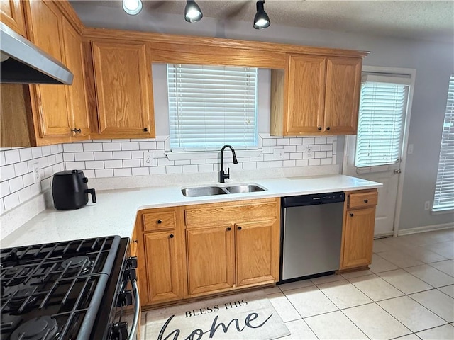 2658 Deann Dr, Ellenwood, GA 30294 - kitchen featuring stainless steel dishwasher, under cabinet range hood, black gas range, decorative backsplash, and light countertops