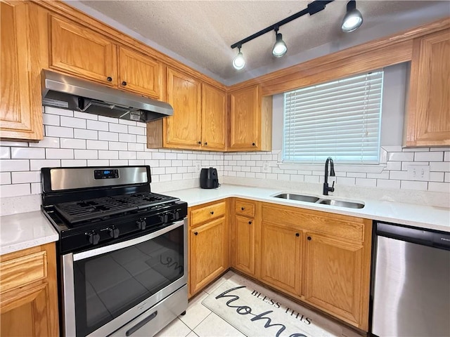 2658 Deann Dr, Ellenwood, GA 30294 - kitchen with appliances with stainless steel finishes, under cabinet range hood, light countertops, decorative backsplash, and light tile patterned floors