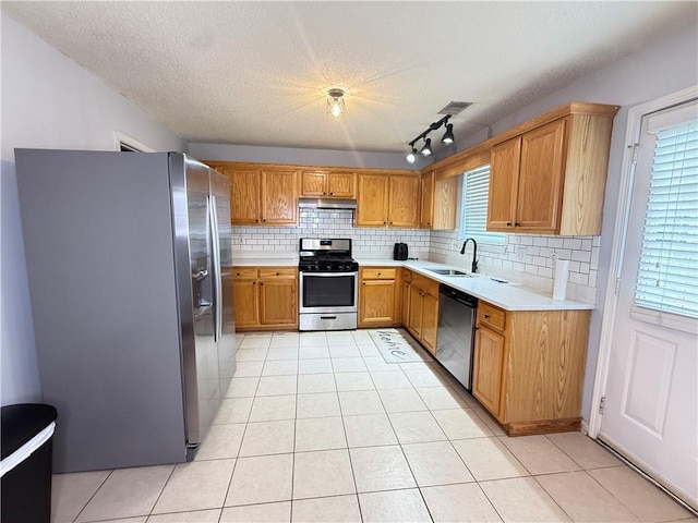 2658 Deann Dr, Ellenwood, GA 30294 - kitchen with stainless steel appliances, under cabinet range hood, light countertops, light tile patterned flooring, and decorative backsplash