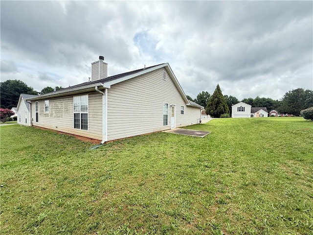 2658 Deann Dr, Ellenwood, GA 30294 - rear view of house with a chimney and a lawn
