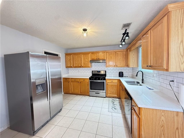 2658 Deann Dr, Ellenwood, GA 30294 - kitchen with appliances with stainless steel finishes, under cabinet range hood, light countertops, tasteful backsplash, and a textured ceiling