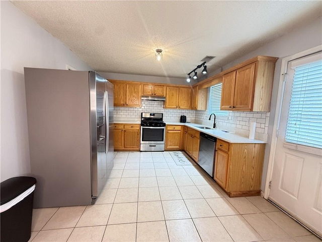 2658 Deann Dr, Ellenwood, GA 30294 - kitchen with stainless steel appliances, light countertops, under cabinet range hood, tasteful backsplash, and light tile patterned floors