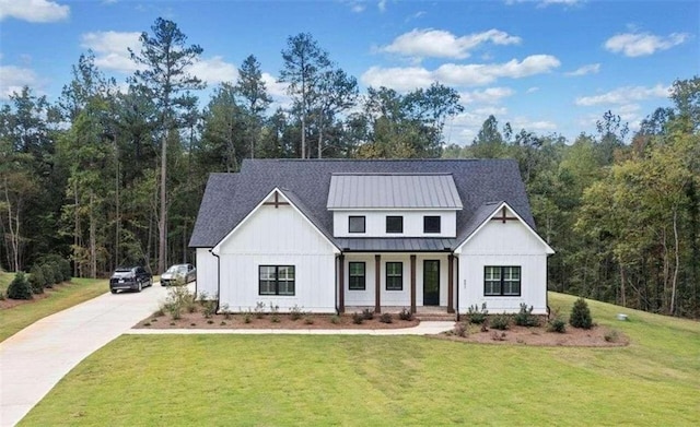 modern inspired farmhouse featuring a standing seam roof, metal roof, a porch, and a front yard