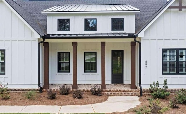 property entrance featuring a standing seam roof, board and batten siding, and covered porch