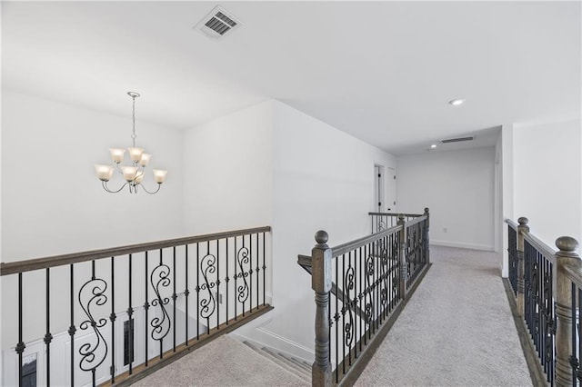 hallway featuring a chandelier and carpet floors