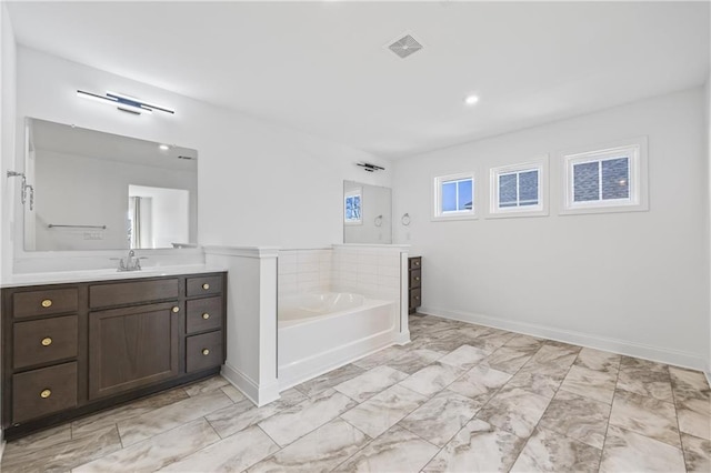 bathroom with vanity and a tub