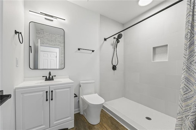 bathroom featuring hardwood / wood-style flooring, vanity, toilet, and walk in shower