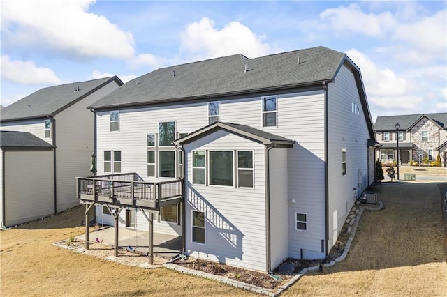 rear view of property with a wooden deck, a yard, and cooling unit