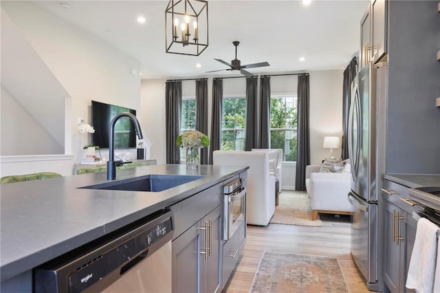 126 Chestnut Cir, Atlanta, GA 30342 - kitchen with appliances with stainless steel finishes, open floor plan, a sink, a ceiling fan, and light wood-style flooring