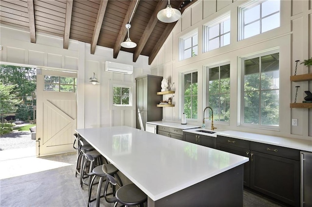 126 Chestnut Cir, Atlanta, GA 30342 - kitchen featuring open shelves, a wall unit AC, wooden ceiling with exposed beams, a sink, and light countertops
