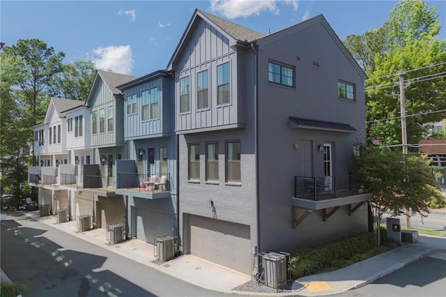 126 Chestnut Cir, Atlanta, GA 30342 - view of property exterior featuring board and batten siding, brick siding, a garage, and central AC unit