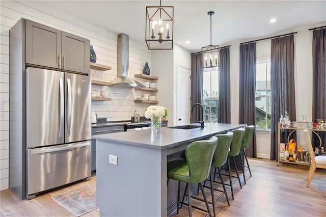 126 Chestnut Cir, Atlanta, GA 30342 - kitchen featuring freestanding refrigerator, wall chimney exhaust hood, open shelves, a sink, and light wood-style flooring