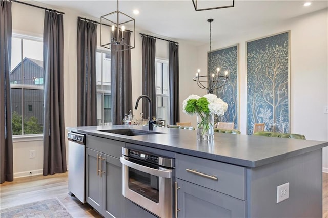 126 Chestnut Cir, Atlanta, GA 30342 - kitchen with a chandelier, stainless steel appliances, gray cabinetry, a sink, and light wood finished floors