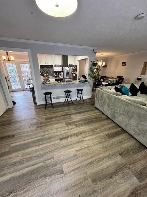 living room with ornamental molding, dark hardwood / wood-style floors, and a notable chandelier