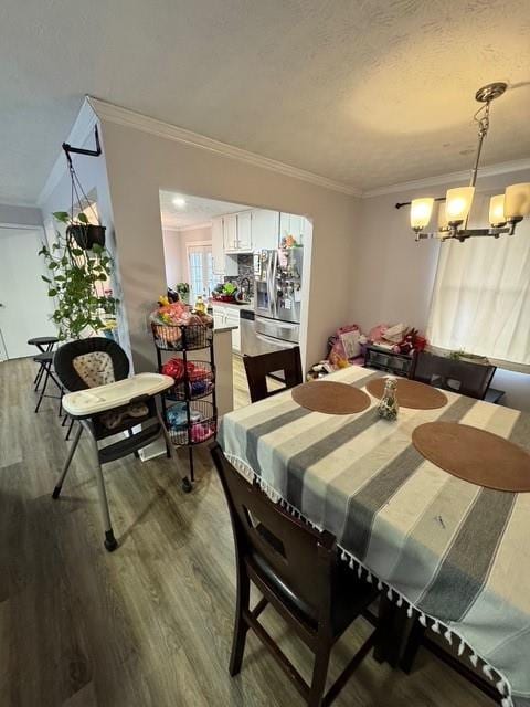 dining area with ornamental molding, wood-type flooring, and a chandelier