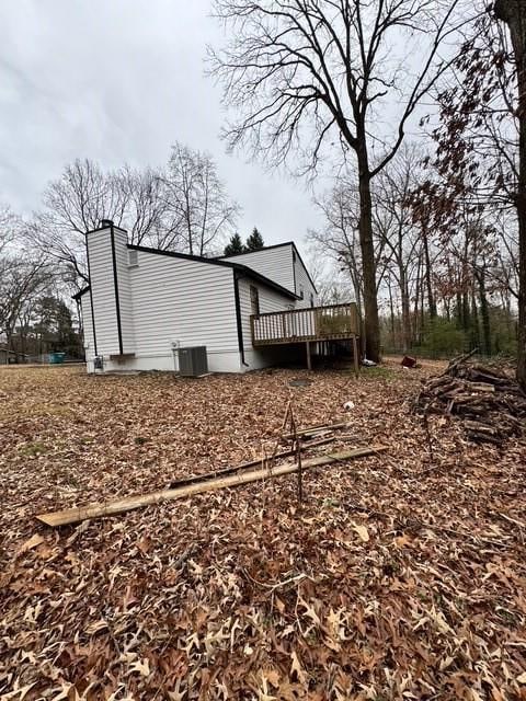 view of side of home with cooling unit and a deck