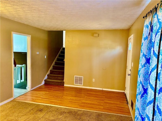 unfurnished room featuring hardwood / wood-style floors and a textured ceiling