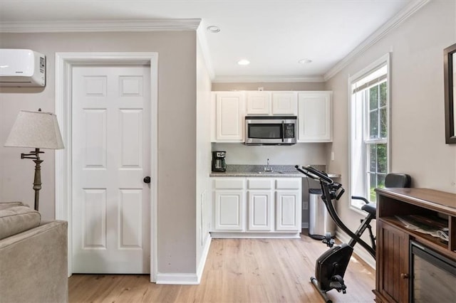 242 Sandhurst Ct, Suwanee, GA 30024 - kitchen featuring stainless steel microwave, a wall mounted air conditioner, a sink, light wood-style flooring, and white cabinetry