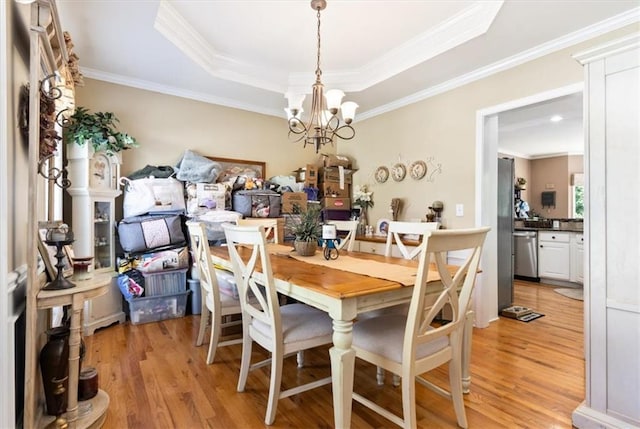 242 Sandhurst Ct, Suwanee, GA 30024 - dining room with light wood-type flooring, a chandelier, a tray ceiling, and crown molding
