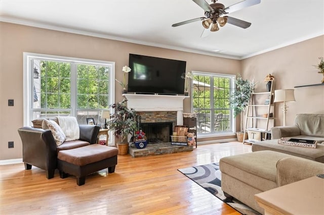 242 Sandhurst Ct, Suwanee, GA 30024 - living area with hardwood / wood-style floors, a stone fireplace, crown molding, a ceiling fan, and baseboards