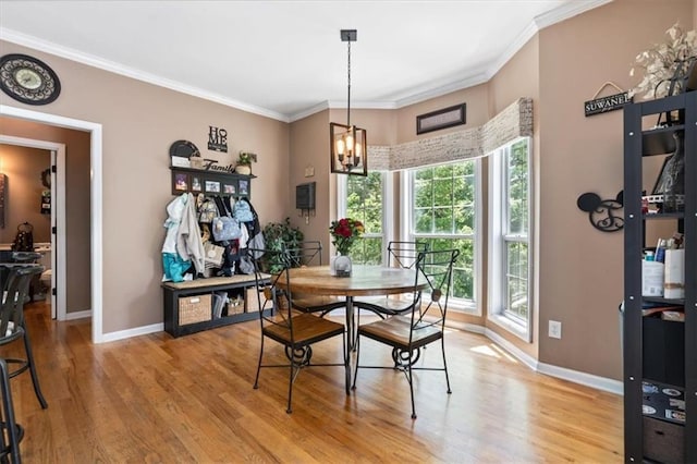 242 Sandhurst Ct, Suwanee, GA 30024 - dining space featuring light wood finished floors, a chandelier, baseboards, and crown molding