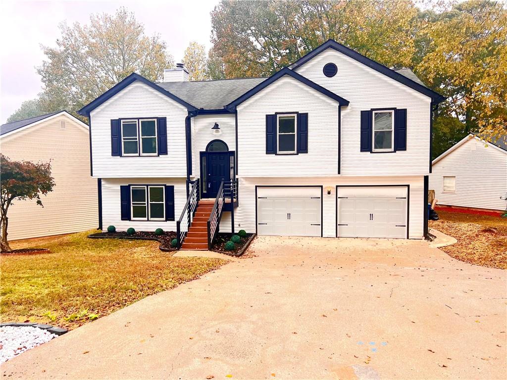 bi-level home with a garage and a front lawn