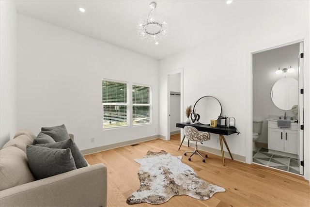 home office featuring light hardwood / wood-style floors, sink, and a chandelier