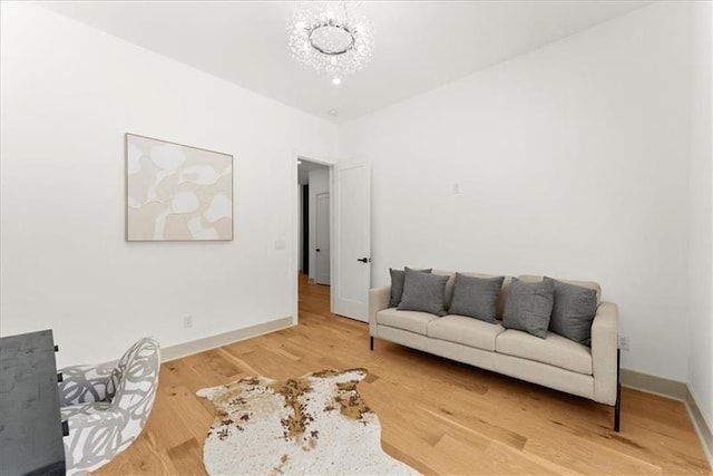 living area with hardwood / wood-style floors and a notable chandelier