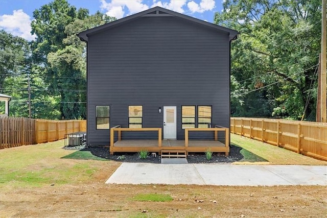 rear view of house featuring central AC, a yard, and a deck