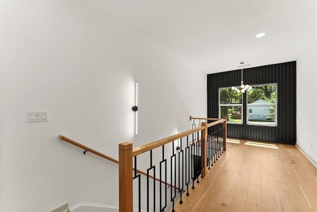 corridor featuring light hardwood / wood-style flooring and an inviting chandelier