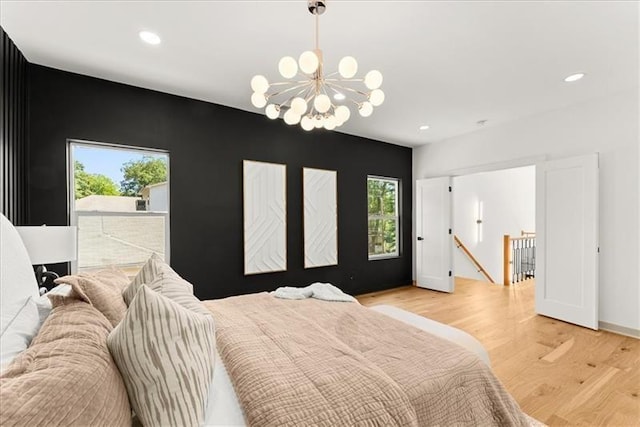 bedroom with a chandelier and light hardwood / wood-style floors