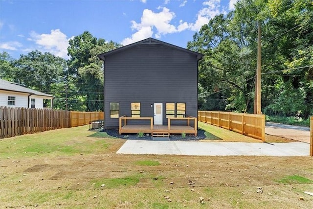 rear view of property with a yard and a wooden deck