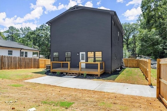 back of house with a wooden deck and a yard