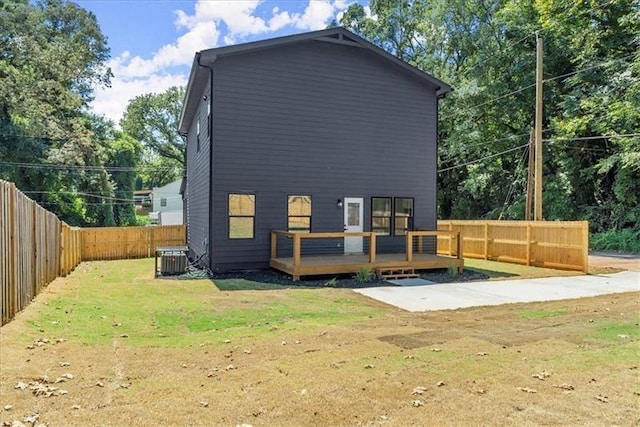 back of house with a deck, central AC unit, and a lawn