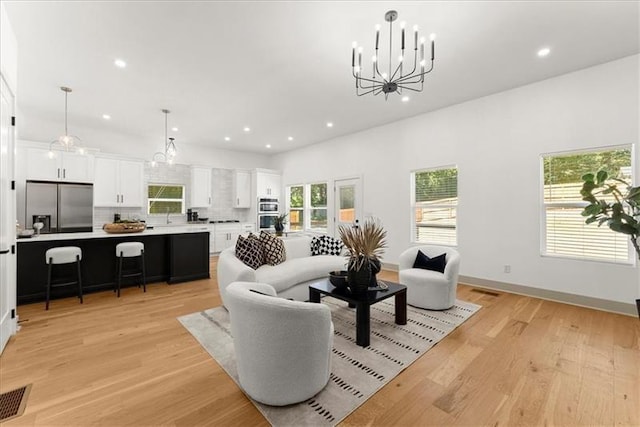 living room with a chandelier and light hardwood / wood-style flooring