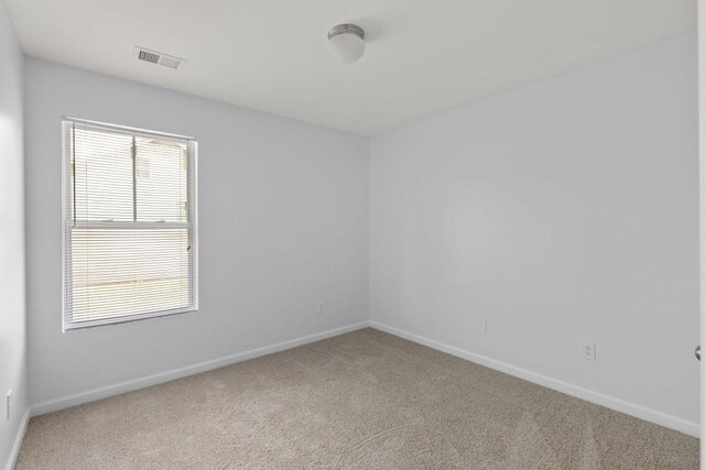 unfurnished room with carpet flooring and baseboards