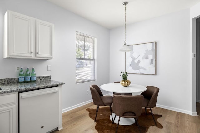 dining area featuring light wood-type flooring and baseboards