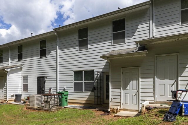 back of house with central AC and a yard