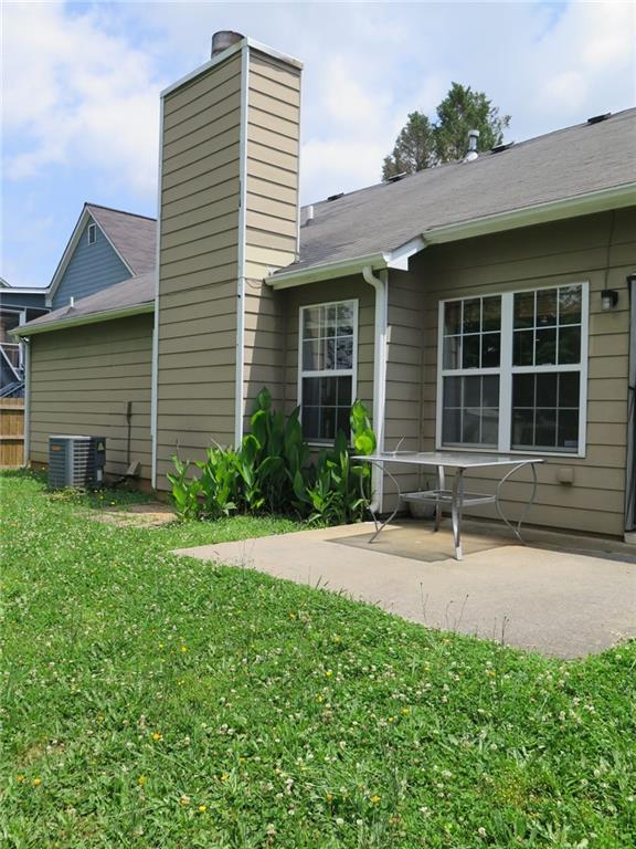 4517 Baker Grove Rd NW, Acworth, GA 30101 - rear view of house featuring a chimney, a patio, a lawn, and central air condition unit