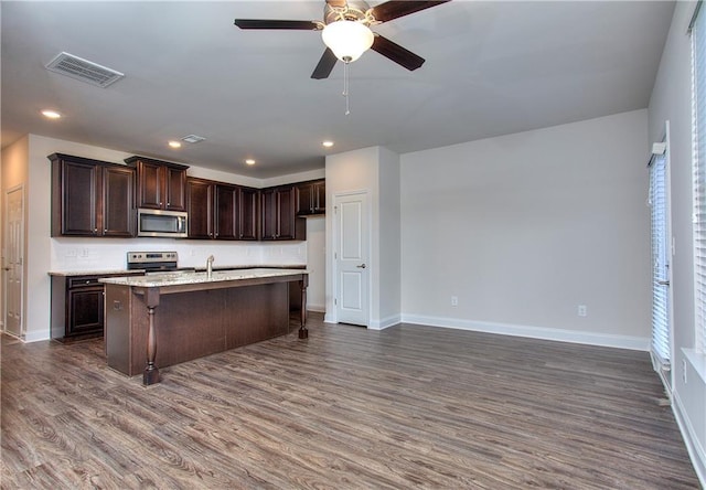 kitchen featuring dark wood-type flooring, stainless steel appliances, tasteful backsplash, dark brown cabinets, and sink