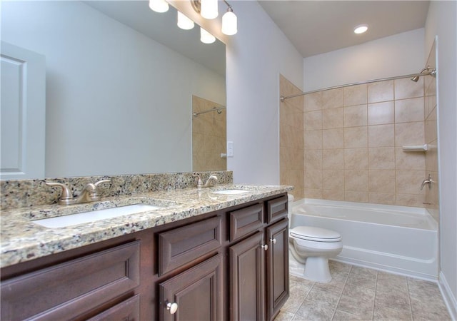 full bathroom with tiled shower / bath, vanity, and toilet