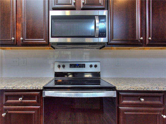 kitchen with stainless steel appliances, backsplash, and light stone countertops