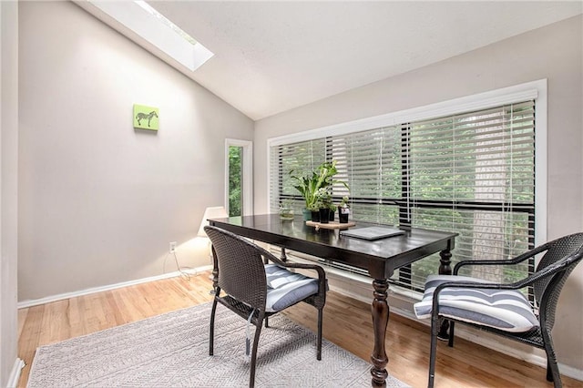 8740 Roswell Rd Unit 2G, Atlanta, GA 30350 - dining room with lofted ceiling, wood finished floors, a skylight, and baseboards