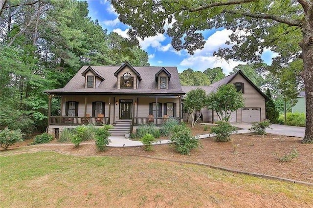 new england style home featuring covered porch, concrete driveway, a front lawn, and a garage