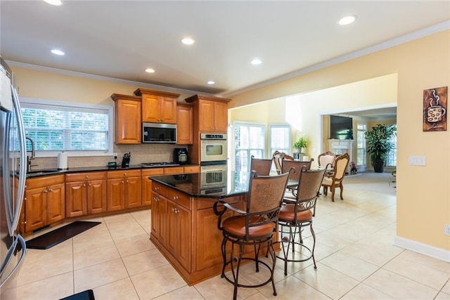 kitchen featuring a kitchen island, crown molding, stainless steel appliances, and backsplash