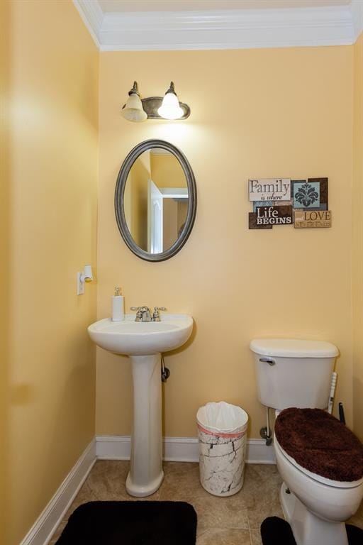 bathroom with toilet, crown molding, and tile patterned flooring