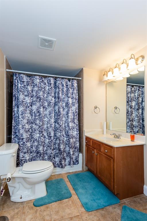 bathroom with vanity, a shower with shower curtain, toilet, and tile patterned flooring