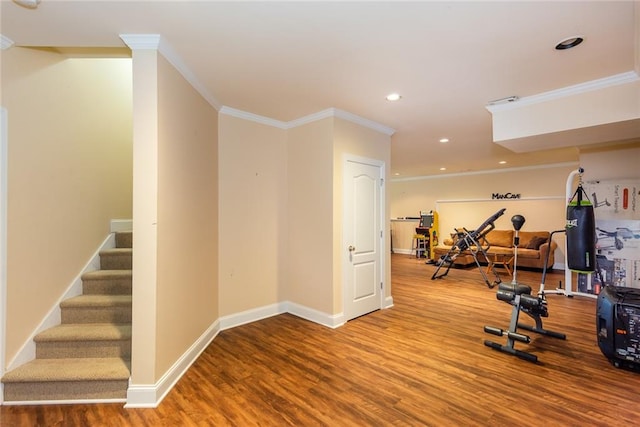 exercise room with hardwood / wood-style floors and crown molding